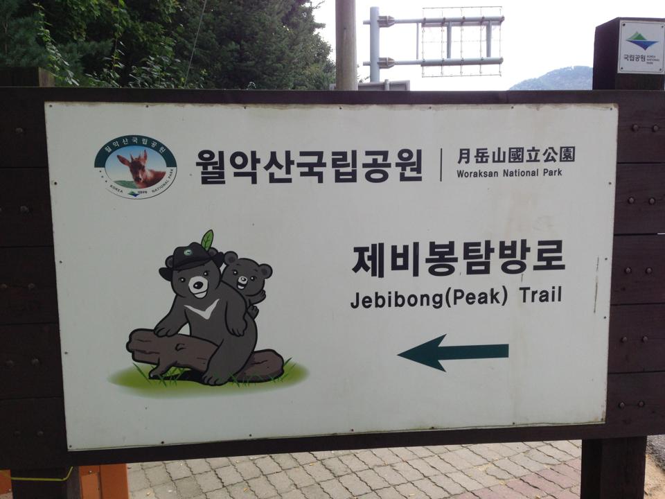 Photograph of a signpost with a picture of cartoon bears, taken in Woraksan National Park, Korea